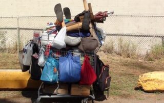Homeless person's shopping cart filled w/belongings